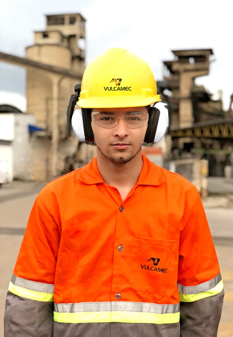 Colaborador da Vulcamec de uniforme laranja e capacete amarelo