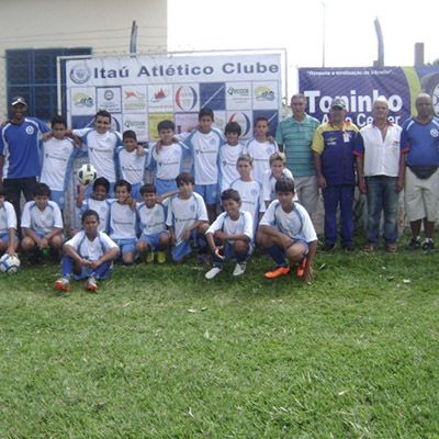 Crianças do Itaú Atlético Clube posando em campo de futebol